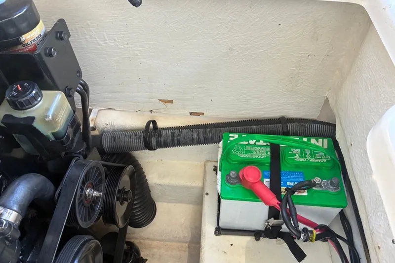 Slide: The Image of Engine compartment of a 2014 Sea Ray 240 Sundeck with visible battery and components. - 58