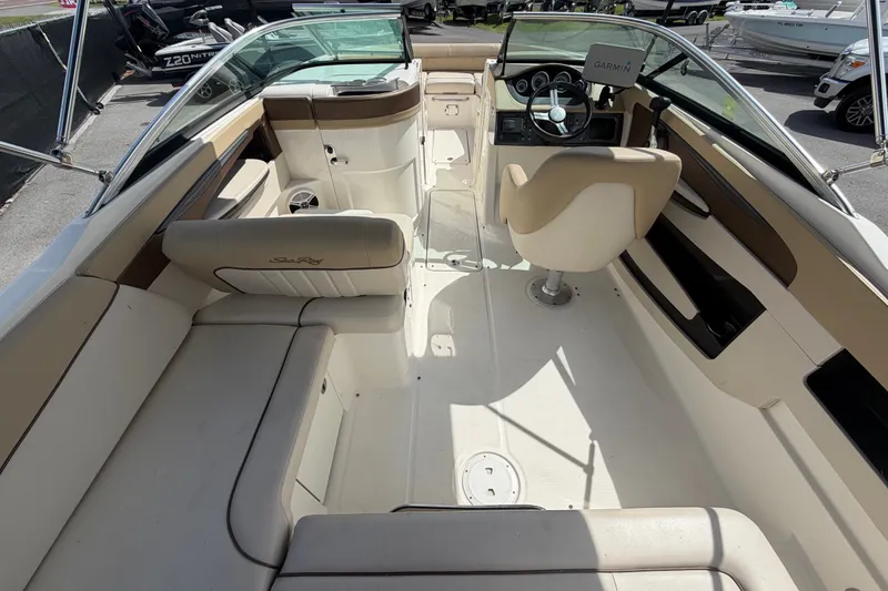 Slide: The Image of 2014 Sea Ray 240 Sundeck interior with beige seating and steering console. - 20