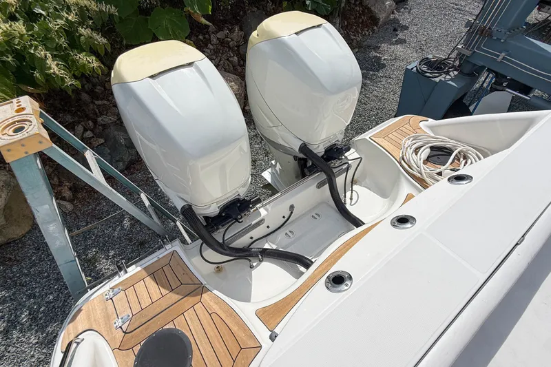 Slide: The Image of 2013 Boston Whaler 32 Justice boat with dual outboard engines and teak deck accents. - 32
