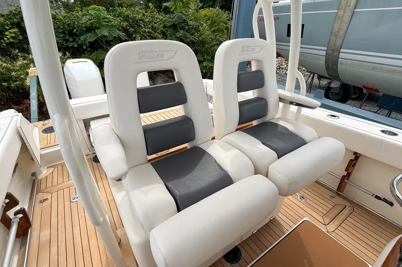 Slide: The Image of Boston Whaler 32 Justice 2013 boat seats with white and gray upholstery on teak deck. - 13