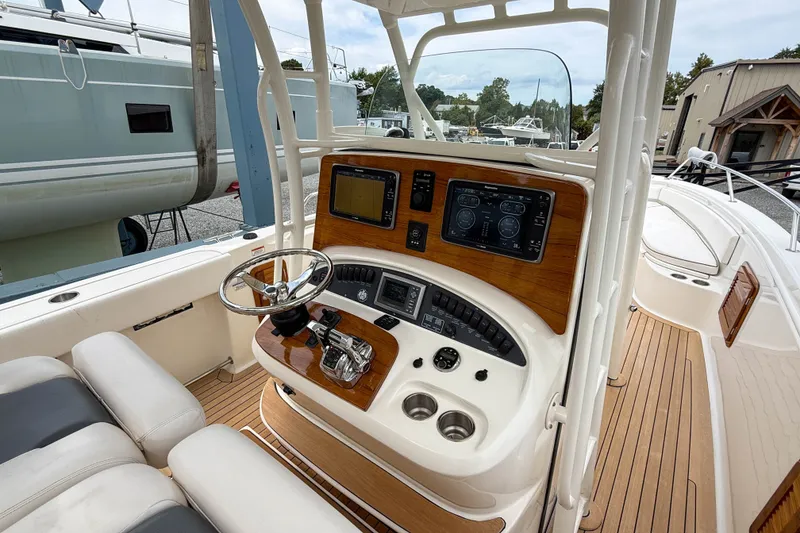 Slide: The Image of 2013 Boston Whaler 32 Justice helm with modern controls and wood accents. - 14