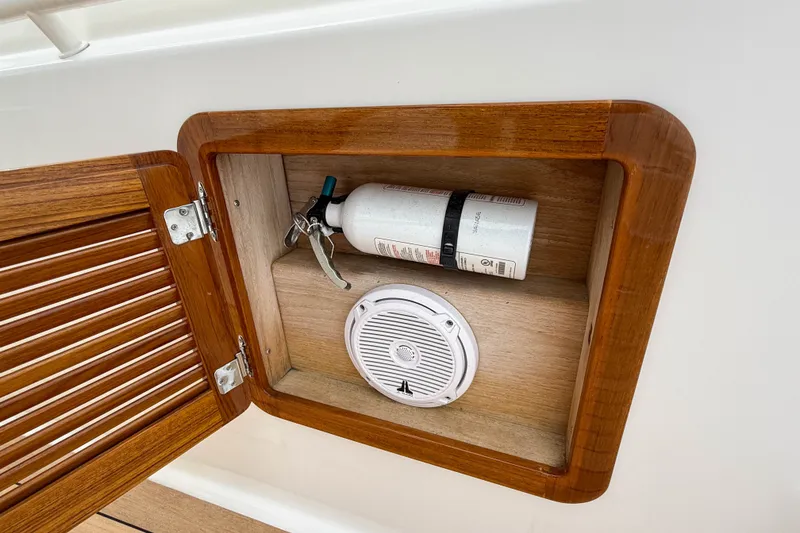 Slide: The Image of Wooden compartment on 2013 Boston Whaler 32 Justice with fire extinguisher and speaker. - 26