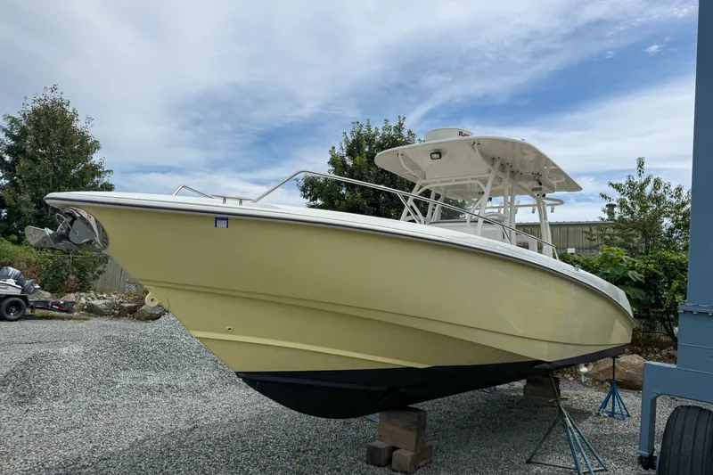 Slide: The Image of 2013 Boston Whaler 32 Justice boat on stands, outdoors, under a cloudy sky. - 2