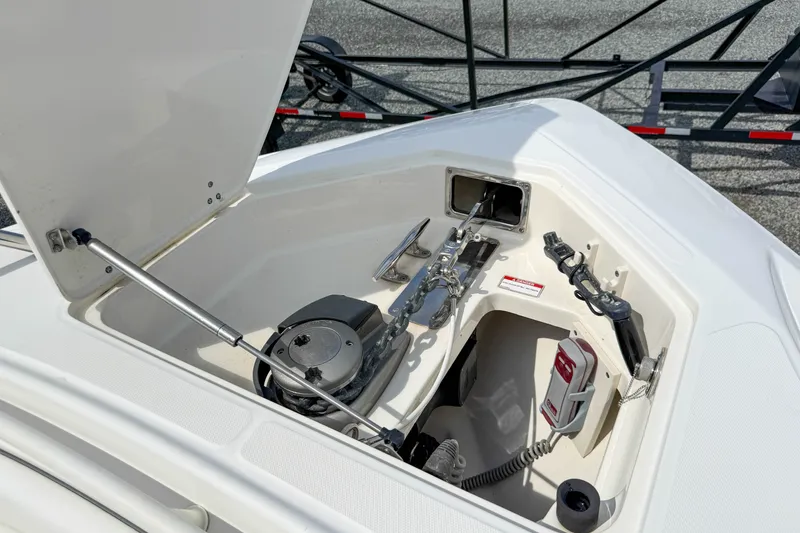 Slide: The Image of Open anchor compartment of 2013 Boston Whaler 32 Justice boat, showcasing anchor and equipment. - 31