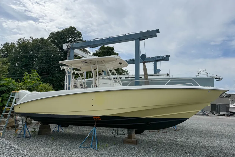 Slide: The Image of 2013 Boston Whaler 32 Justice boat on stands in a marina setting. - 1