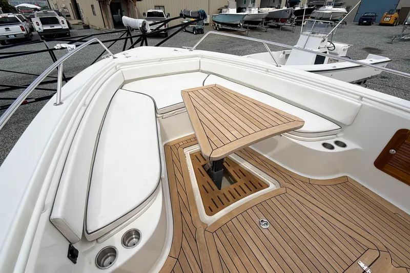 Slide: The Image of 2013 Boston Whaler 32 Justice boat interior with teak flooring and seating area. - 18