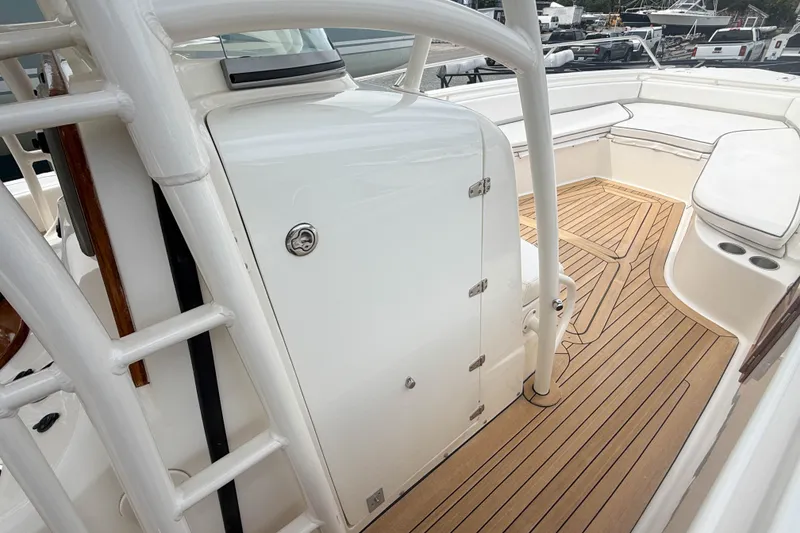Slide: The Image of 2013 Boston Whaler 32 Justice boat interior with teak flooring and seating area. - 21
