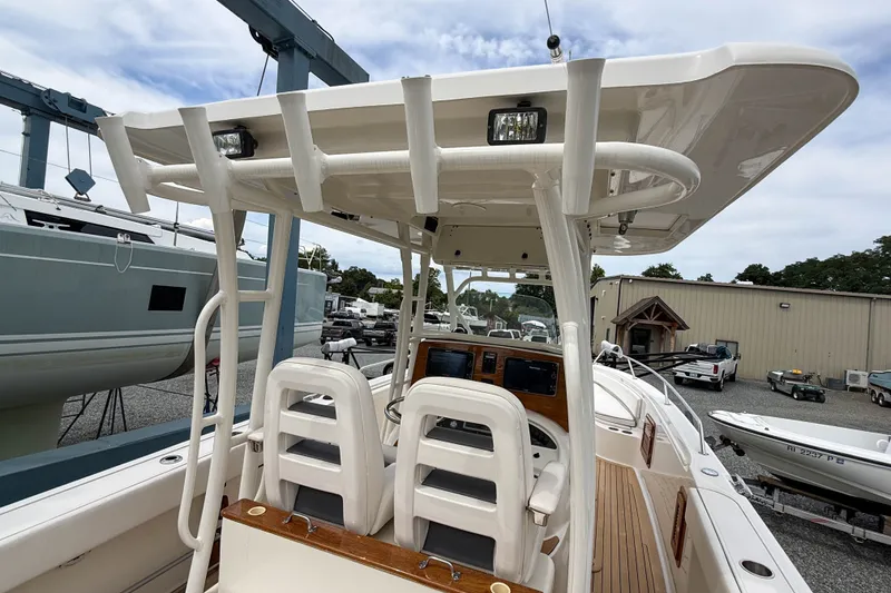 Slide: The Image of 2013 Boston Whaler 32 Justice boat interior with helm and seating, docked in a marina. - 10