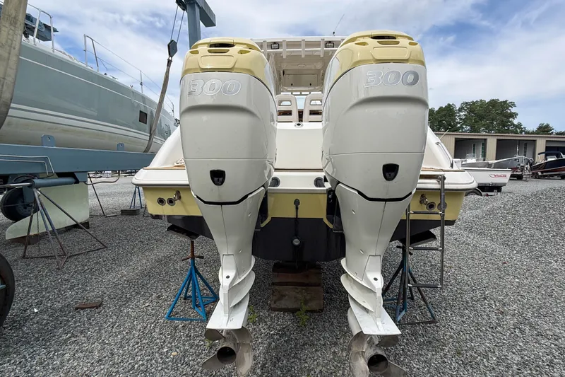 Slide: The Image of 2013 Boston Whaler 32 Justice with twin 300 horsepower outboard engines, displayed on stands. - 5