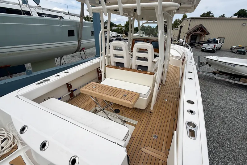 Slide: The Image of 2013 Boston Whaler 32 Justice boat with teak deck and seating area in a marina. - 7