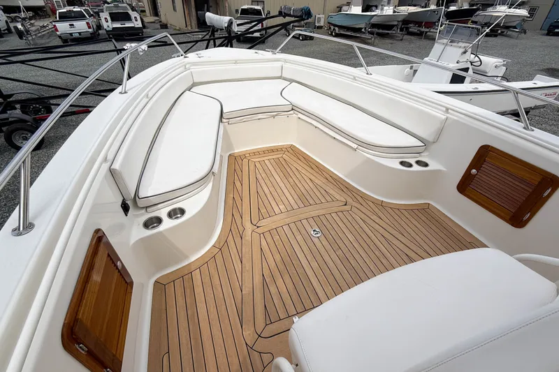 Slide: The Image of 2013 Boston Whaler 32 Justice boat interior with cushioned seating and teak flooring. - 17