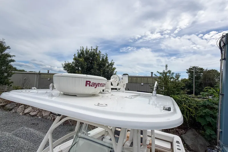 Slide: The Image of 2013 Boston Whaler 32 Justice boat with Raymarine radar, docked outdoors under cloudy sky. - 24