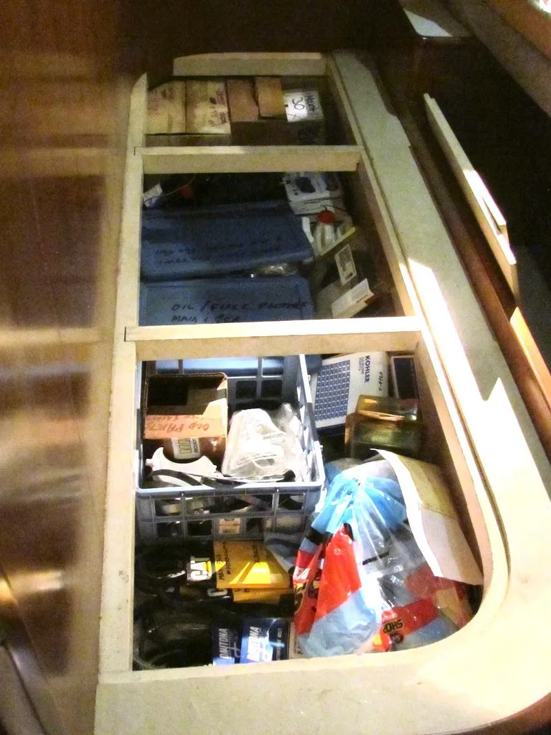 Slide: The Image of Storage compartment on a 1997 Hyatt 55 boat, filled with various tools and supplies. - 16
