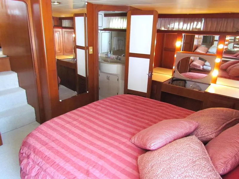 Slide: The Image of Luxurious 1997 Hyatt 55 yacht bedroom with red bedding and elegant wood finishes. - 22