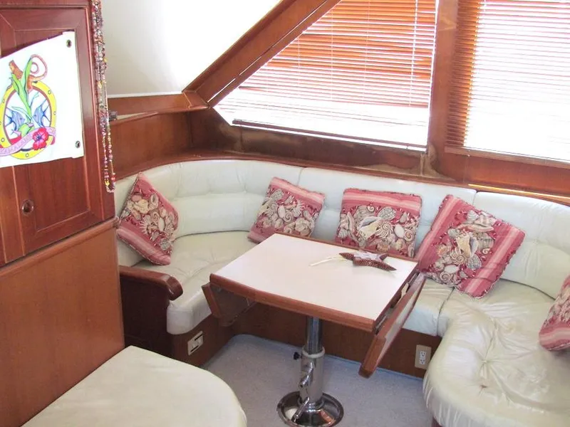 Slide: The Image of Luxurious yacht interior with white leather seating, decorative pillows, and a wooden table, Hyatt 55 model. - 18