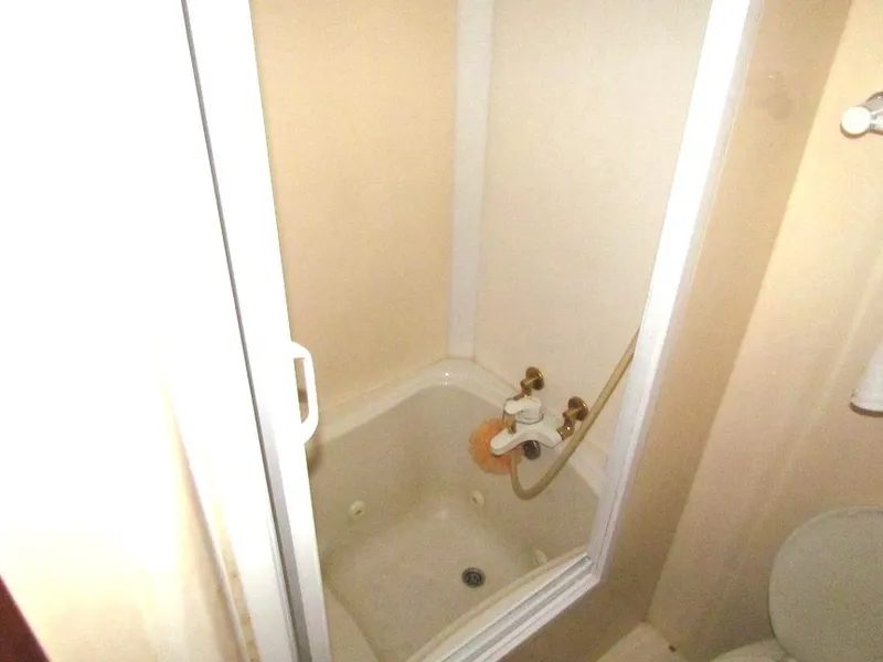 Slide: The Image of Compact shower stall with white walls and a sliding door, featuring vintage fixtures. - 25