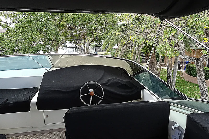 Slide: The Image of Helm of 2010 Azimut 100 Leonardo yacht with covered controls, surrounded by lush greenery. - 71