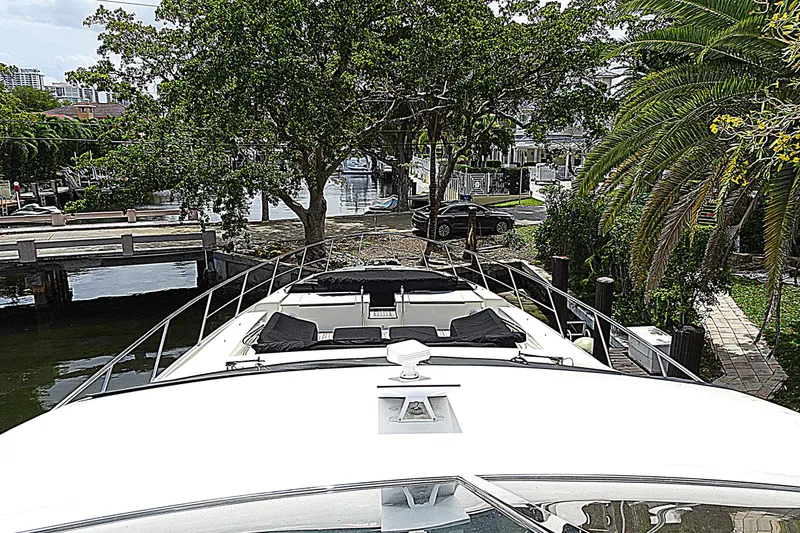 Slide: The Image of Azimut 100 Leonardo yacht docked near lush greenery and waterfront homes. - 81