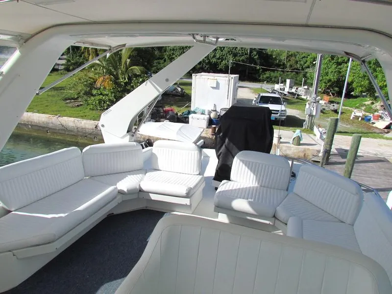 Slide: The Image of Spacious seating area on a 1998 Navigator 53 yacht, docked near lush greenery. - 3