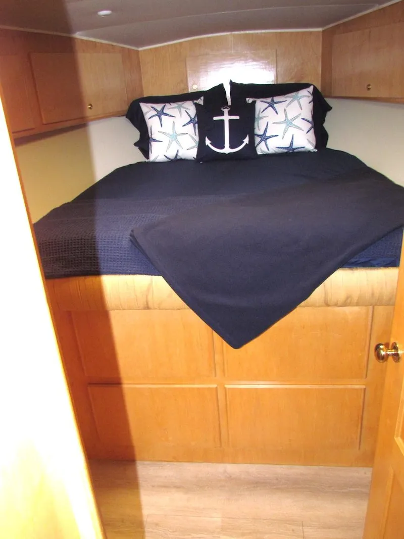 Slide: The Image of Cozy bedroom in 1998 Navigator 53 yacht with nautical-themed pillows and wooden cabinetry. - 24