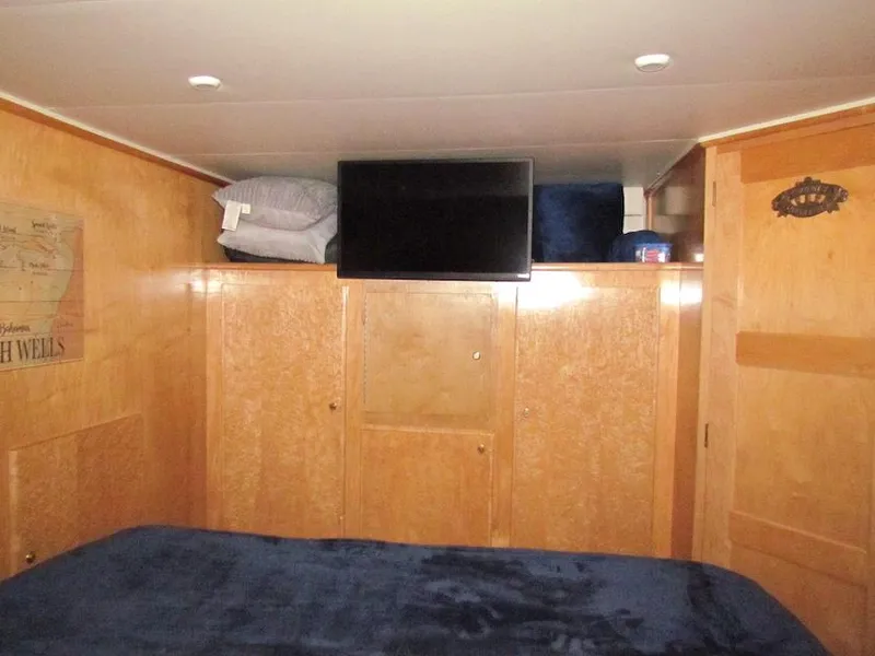 Slide: The Image of Cozy cabin interior of 1998 Navigator 53 yacht with wood paneling and mounted TV. - 31