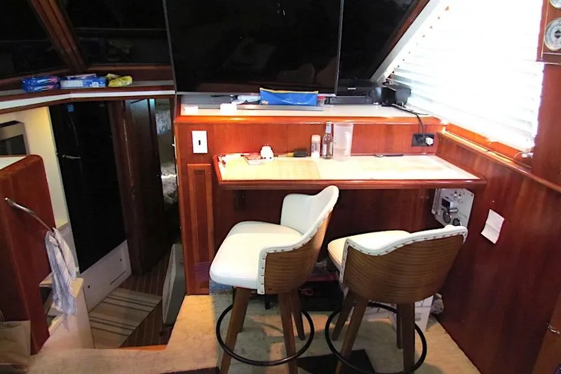 Slide: The Image of Interior of 1992 Hatteras 40 Motor Yacht with bar stools and wooden cabinetry. - 10