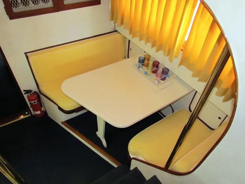 Slide: The Image of 1972 Hargrave 67 Motor Yacht interior with yellow booth seating and table. - 23