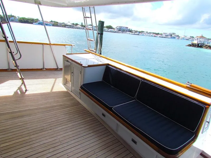 Slide: The Image of 1972 Hargrave 67 Motor Yacht deck with seating, overlooking serene waterfront. - 14