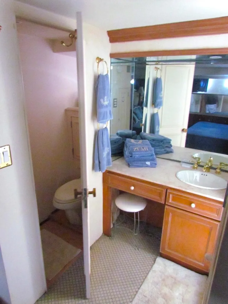 Slide: The Image of 1972 Hargrave 67 Motor Yacht bathroom with wooden vanity, mirror, and blue towels. - 44