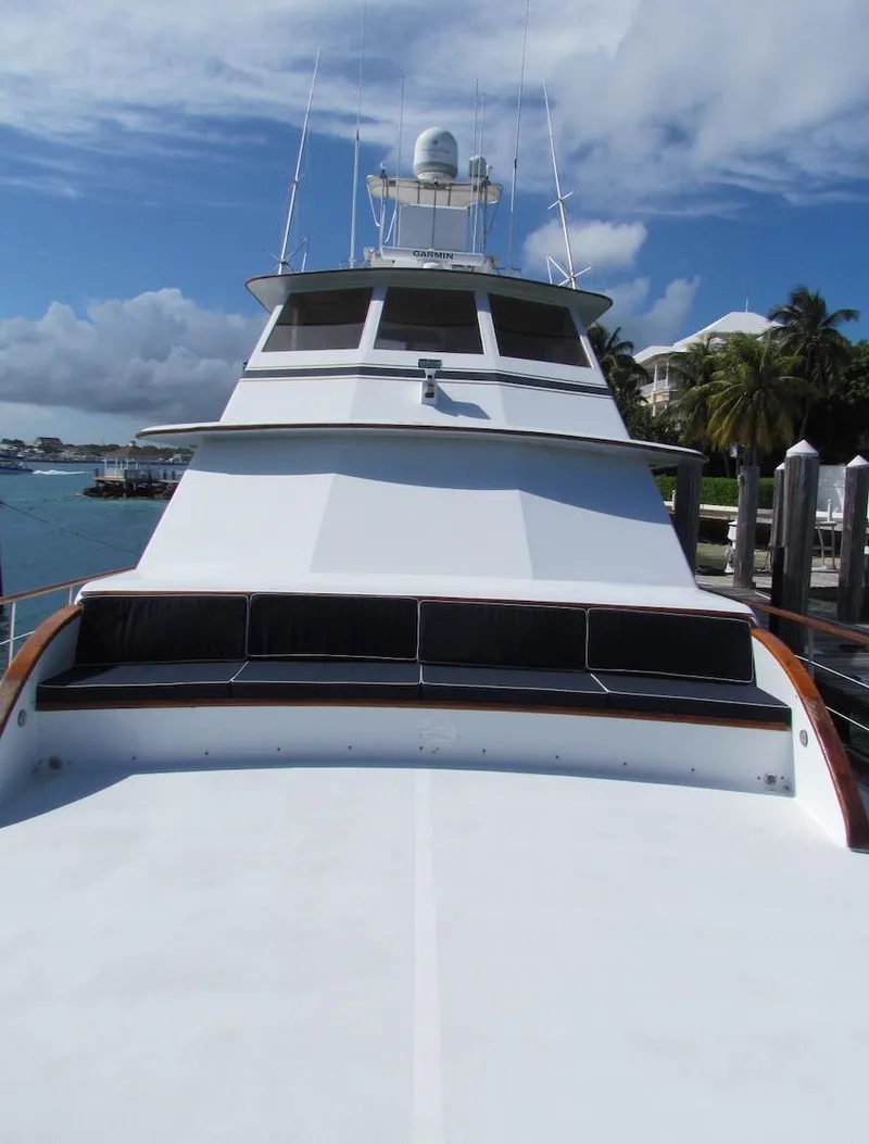 Slide: The Image of 1972 Hargrave 67 Motor Yacht docked, showcasing sleek design and spacious deck under a clear sky. - 2