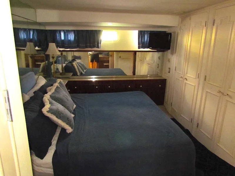 Slide: The Image of 1972 Hargrave 67 Motor Yacht bedroom with blue bedding and mirrored dresser. - 11