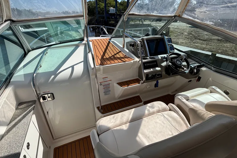 Slide: The Image of 2018 Chaparral 310 Signature boat interior with helm, seating, and navigation controls. - 11