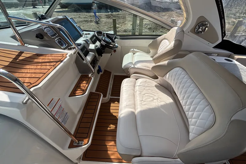Slide: The Image of 2018 Chaparral 310 Signature boat interior with luxurious seating and modern dashboard. - 10