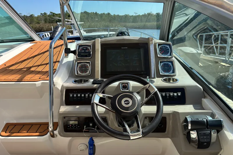 Slide: The Image of 2018 Chaparral 310 Signature boat dashboard with steering wheel and navigation controls. - 9