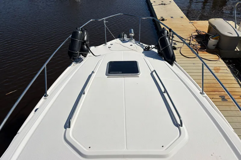 Slide: The Image of 2018 Chaparral 310 Signature boat docked, showing bow deck and railing. - 27