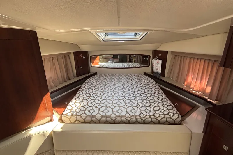 Slide: The Image of Luxurious interior of 2018 Chaparral 310 Signature yacht with elegant bedding and wood accents. - 15
