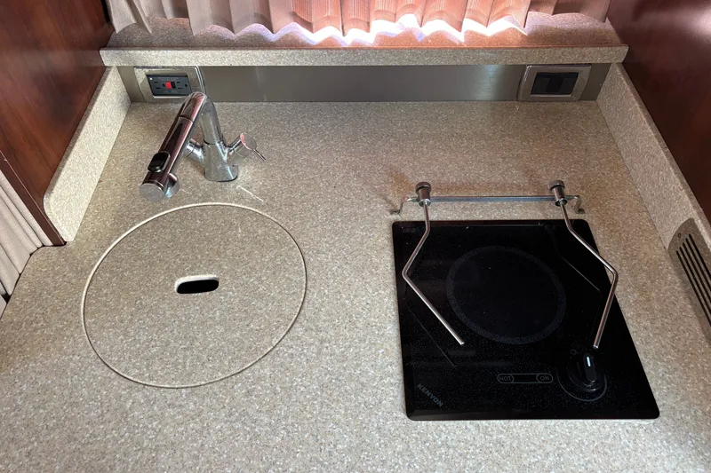 Slide: The Image of 2018 Chaparral 310 Signature boat kitchen with sink and electric cooktop. - 20