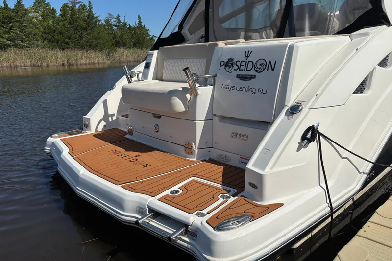 Slide: The Image of 2018 Chaparral 310 Signature boat docked, featuring teak deck and "Poseidon" branding. - 4