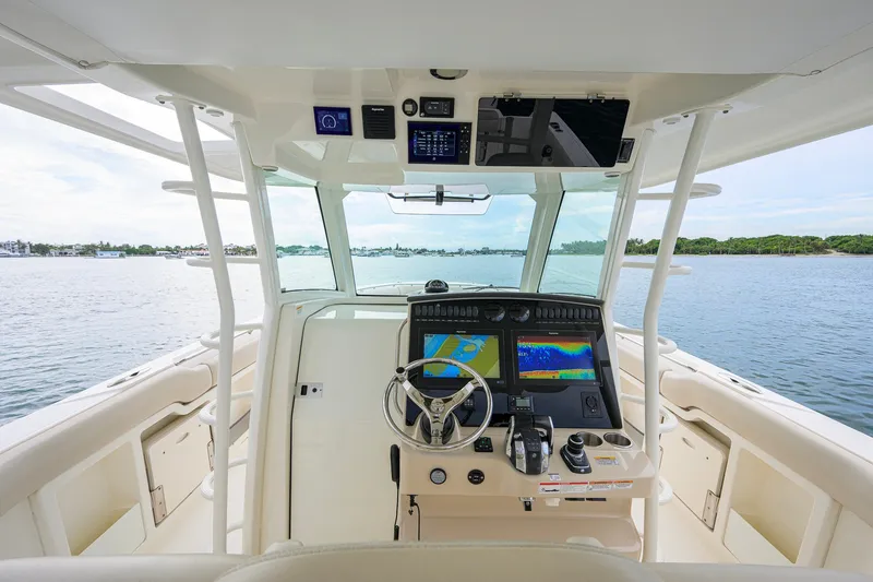 Slide: The Image of Cockpit view of 2018 Boston Whaler 380 Outrage boat on calm water. - 2