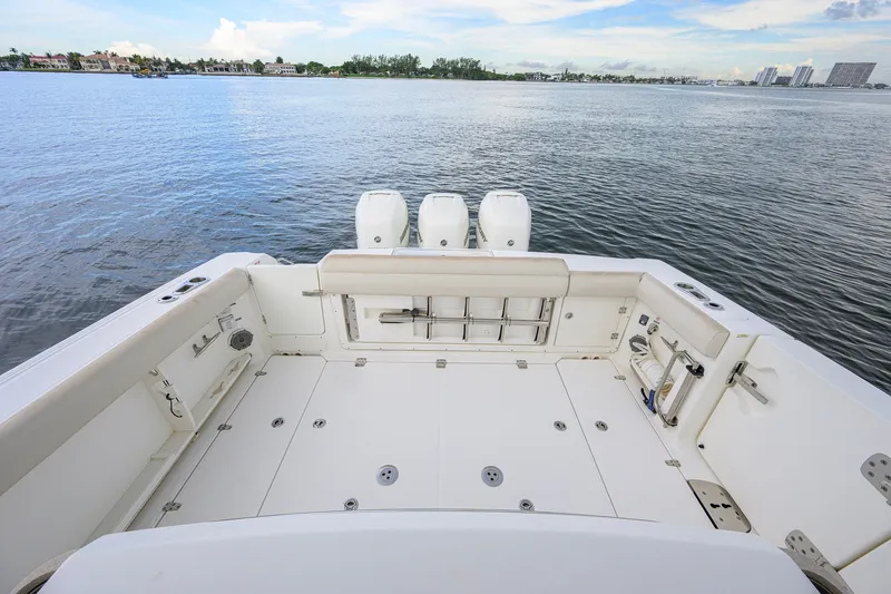Slide: The Image of 2018 Boston Whaler 380 Outrage boat deck with triple engines on calm water. - 50