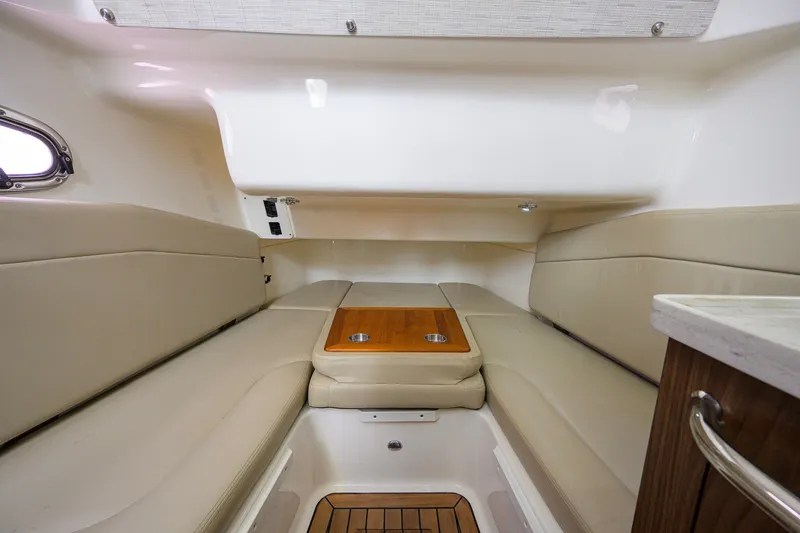 Slide: The Image of Interior cabin of 2018 Boston Whaler 380 Outrage with beige seating and wooden table. - 42
