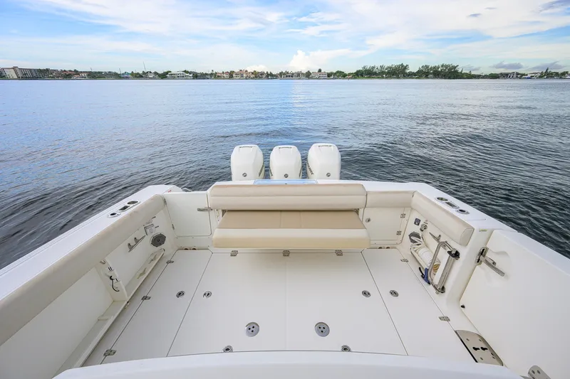 Slide: The Image of 2018 Boston Whaler 380 Outrage boat deck with triple engines on calm water. - 53