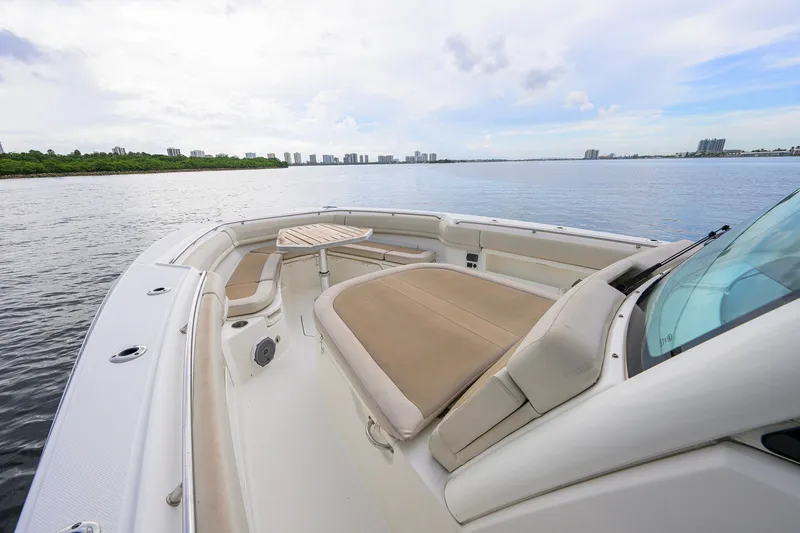 Slide: The Image of 2018 Boston Whaler 380 Outrage boat interior with seating and table on calm water. - 18
