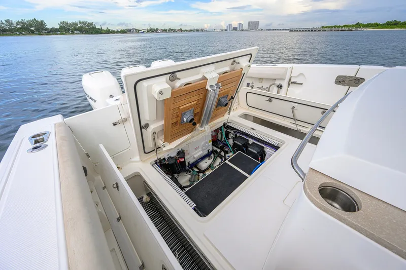 Slide: The Image of Boston Whaler 380 Outrage 2018 boat with open engine compartment, docked by the water. - 69