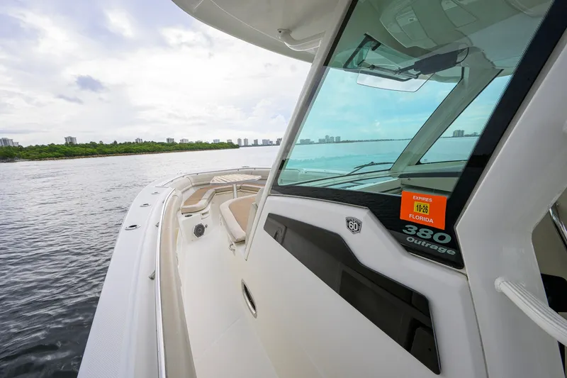 Slide: The Image of 2018 Boston Whaler 380 Outrage boat cruising on calm waters near a city skyline. - 17