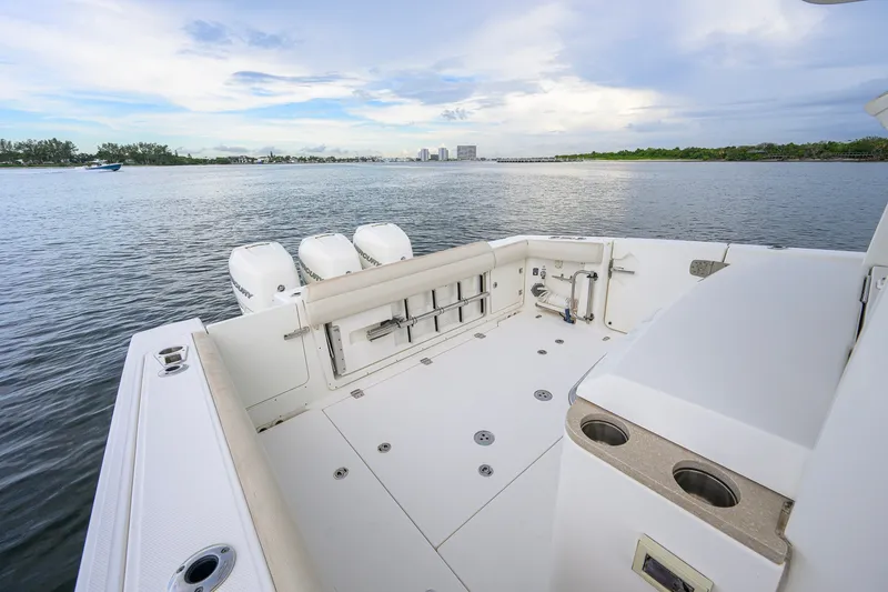Slide: The Image of 2018 Boston Whaler 380 Outrage boat deck with triple Mercury engines on calm water. - 49