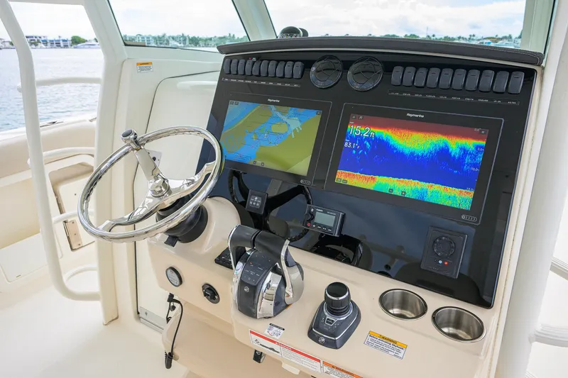 Slide: The Image of Control panel of a 2018 Boston Whaler 380 Outrage with navigation screens and steering wheel. - 15