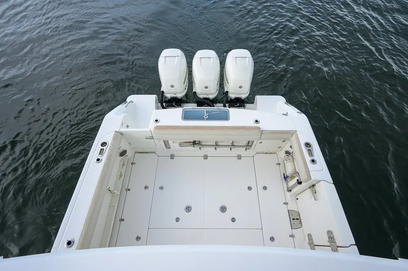 Slide: The Image of 2018 Boston Whaler 380 Outrage boat with triple outboard engines on calm water. - 52