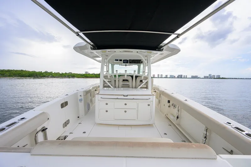 Slide: The Image of 2018 Boston Whaler 380 Outrage boat interior with seating and storage, overlooking calm waters. - 54