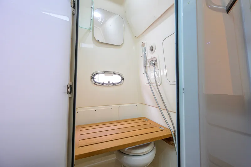 Slide: The Image of Interior of 2018 Boston Whaler 380 Outrage boat bathroom with wooden seat and shower. - 44